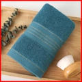 Thick teal absorbent cotton towel with gold stripes on a wooden tray with brush - Cotton Gold Border Blue (Towel)