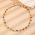 Golden necklace with colorful clover pendants in red, blue, and green on stone decor - KC Gold Four Leaf Clover Necklace