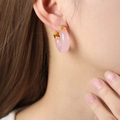 Orecchini geometrici chic in resina rosa chiaro con dettagli dorati su modella - Oro Rosa