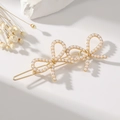 Detail of golden bow hair clip with white artificial pearls on an elegant white background - Pearl Gold