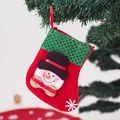 Red felt Christmas stocking with green sequins and snowman hanging on a branch - Snowman