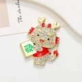 Cartoon Chinese dragon brooch with red enamel and rhinestones holding a green luck sign - Dragon Wealth - Matte Gold