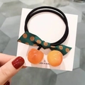 Détail de l'élastique à cheveux avec pendentifs cerise orange et nœud à pois - Élastique Cerise / Jaune