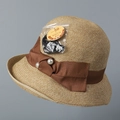 Detalle de sombrero de paja con etiqueta UPF 50+ y elegante lazo de cinta con perlas - M (56-58cm) / Caramelo