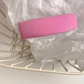 Detailed macro view of a pink ribbed fabric hair clip placed in a white metal basket - Pink Purple