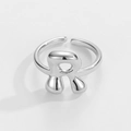 Nahaufnahme des verstellbaren silbernen Buchstabe-R-Rings mit geschmolzener Metallstruktur - Buchstabe R