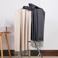 Detail of beige and dark grey cashmere scarves with tassels on a metal rack - No.39 Beige Dark Grey