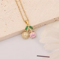 Macro shot of cherry pendant necklace with pink zircon and gold-plated chain detail - Cherry