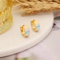 Elegant gold heart earrings with light blue gems and white crystals on ceramic tray - Lake Blue