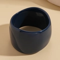 Nahaufnahme von breitem, marineblauem Harz-Armband mit glatter, glänzender Oberfläche - Blau