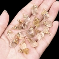 Hand holding irregular raw crystal pendants with gold plated edges and loops - Citrine