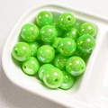Close-up of 14mm green acrylic shell beads in a tray for DIY jewelry making - Fruit Green
