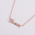 Collana con pendente Forever in oro rosa e zirconi cubici su sfondo chiaro - Oro rosa