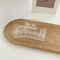 Transparent acrylic rectangular hollow hair claw clip with silver spring on a wooden tray - Transparent White