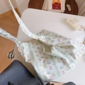 Detailansicht einer weißen Baumwolltasche mit Blumenmuster auf einem weißen Tisch - Hellgrün Gestreift Floral