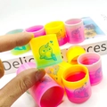 Hand holding a colorful plastic spring toy with a cute narwhal pattern and rainbow finish - Narwhal Pattern