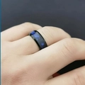 Close-up of a men's black titanium steel ring with a blue patterned inlay on a finger - Size 6 / Dark Blue Shell Ring