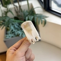 Detail of hand-held beige marble acetate hair claw clip with Barrette La France text - Cream Frost