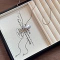 Primer plano del elegante collar de perlas con mariposa y pedrería en un estuche de lujo - Plateado
