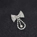 Sparkling silver bow brooch with hanging round rhinestone pendant on black background - Solid Bow With Water Drop Pendant