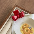 Macro view of a red acetate bow hair claw clip featuring elegant golden French lettering - Red
