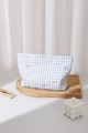 Detail of blue plaid fabric pouch featuring delicate bow embroidery and woven brand label - Large / Blue Plaid