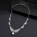 Dettaglio ciondolo ali d'angelo argento con strass e perla bianca su legno scuro - Collana di Perle con Ali