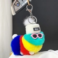Macro detail of colorful plush caterpillar keychain with pink sunglasses and white knit hat - Green Yellow Red Blue