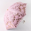 Detail eines rosa Sonnenschirms mit 3D-Spitzenblumenstickerei und goldfarbenen Pailletten - Zweifach / Rosa