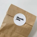 Brown kraft paper packaging bag with a round white Thank You sticker on a white background - Round White Stickers (6 Pieces per Sheet)