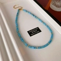 Detail of 925 silver beaded necklace with blue stones and gold clasp on a display tray - Blue Turquoise Texture Style