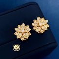 Luxurious gold lotus flower stud earrings with sparkling crystals on a blue jewelry box - Gold Stud Earrings