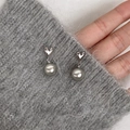 Silver heart earrings with grey metallic pearls pinned on a grey knitted fabric surface - EH0330/Heart Pendant Silver Grey Pearl Stud