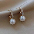 Elegant gold-plated C-shaped earrings with CZ stones and white pearls on silk background - Half Circle Zirconia Pearl Earring (ER21Y0534)