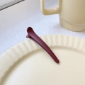 Deep red matte 8cm duckbill hair clip displayed on a cream ceramic plate - Coffee