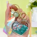 Green heart-shaped liquid quicksand keychain with pink sequins and laser strap - Green