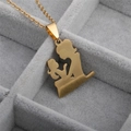Close-up of golden mother and child pendant necklace in a gray velvet jewelry organizer - Mother and Child Embracing Gold Pendant Necklace