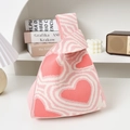 Knit tote bag with pink heart pattern in a minimalist lifestyle setting - Pink and White Heartbeat