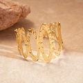 Dettaglio del bracciale rigido dorato con design ondulato e superficie martellata - Oro