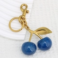 Portachiavi ciliegia blu glitterato con anello in metallo dorato su sfondo bianco pulito - Ciliegia Blu Chiusura Oro Rosa