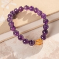 Détail macro du bracelet en perles d'améthyste avec accents dorés sur un carnet vintage - Bracelet Élastique en Perles d'Améthyste Naturelle - Boîte Cadeau