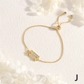 Close-up of golden adjustable bracelet featuring a school bus charm with white zircons - Truck