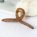Amber tortoiseshell hair claw clip with matte finish and twisted loop design on white cloth - Glossy Finish / Mustard Yellow
