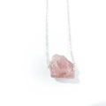 Macro shot of irregular natural rose quartz raw stone pendant with silver chain necklace - Strawberry Quartz