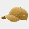 Close-up of distressed ginger yellow baseball cap with frayed edges and washed cotton texture - Yellow
