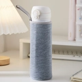 Gray fabric water bottle sleeve with carrying strap on a cozy white table - Gray