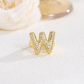 Dettaglio anello dorato con lettera W a palloncino e pavé di cristalli di zircone - Lettera W