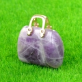 Mini colgante de bolso en amatista con asa dorada sobre fondo de hierba verde - Amatista