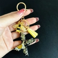 Detail of resin letter X keychain with white dried flowers, gold bee and yellow tassel - Letter X