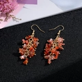 Macro shot of handmade natural stone long tassel earrings with red orange crystals - Gold Hook Style / Orange Red Chip Stone
